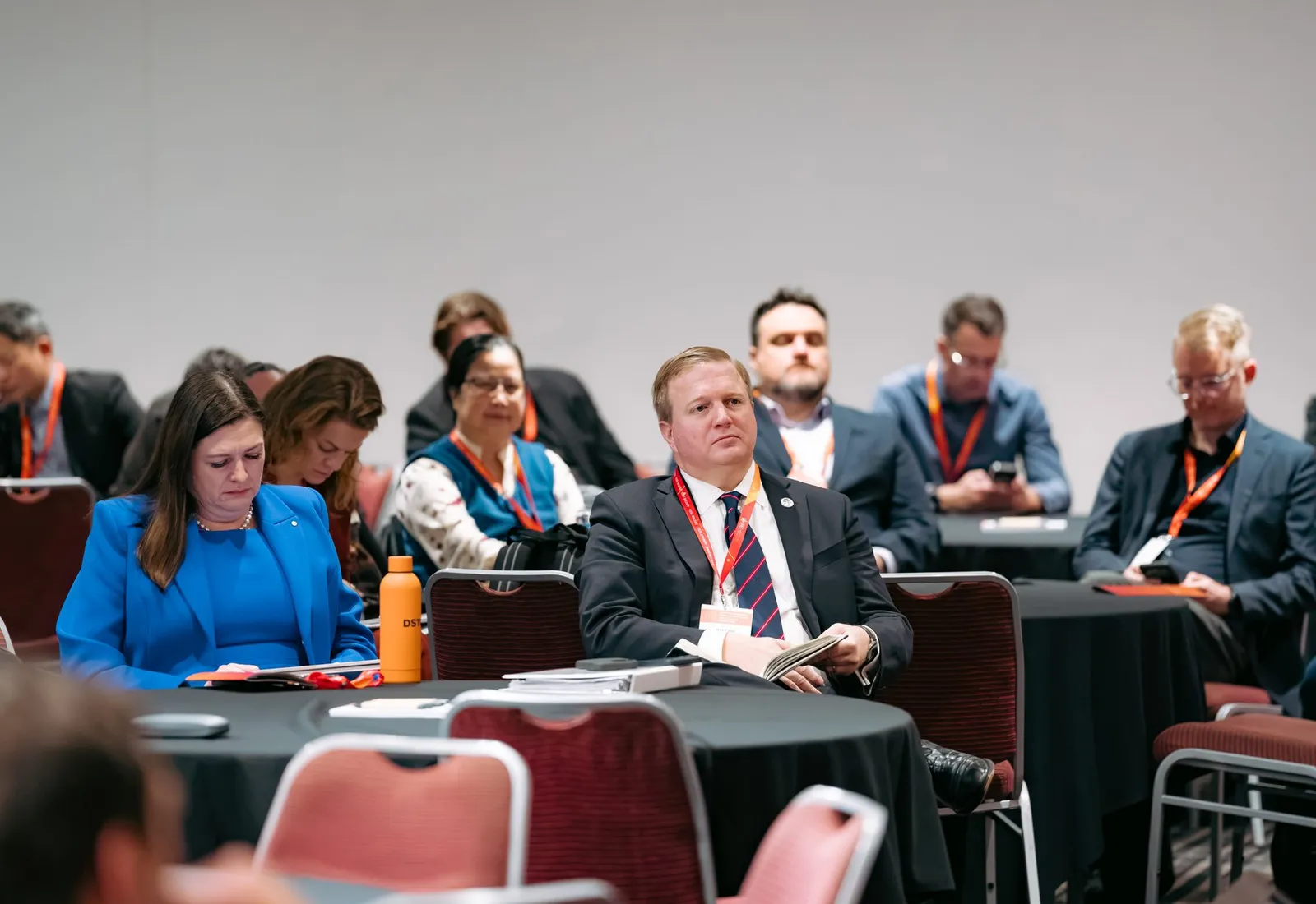 Delegates seated at round tables in an ADSTAR 2026 breakout session, phones and notes on the tables